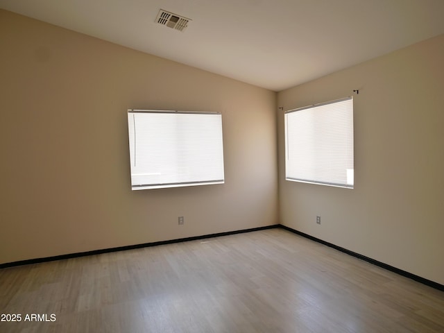 43241 W Kristal Ln, Maricopa, AZ 85138 - empty room with light wood-type flooring, lofted ceiling, and baseboards
