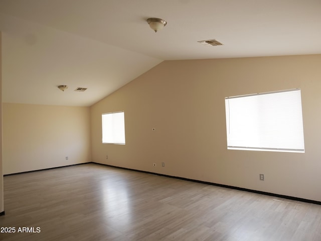 43241 W Kristal Ln, Maricopa, AZ 85138 - unfurnished room with lofted ceiling, light wood finished floors, and baseboards