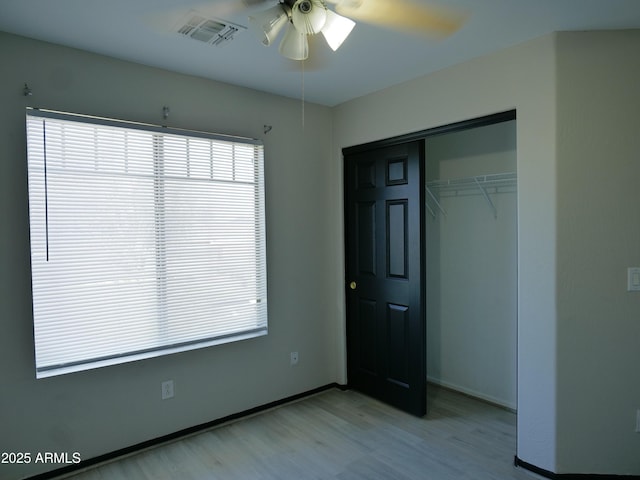 43241 W Kristal Ln, Maricopa, AZ 85138 - unfurnished bedroom featuring light wood finished floors, multiple windows, a closet, and ceiling fan