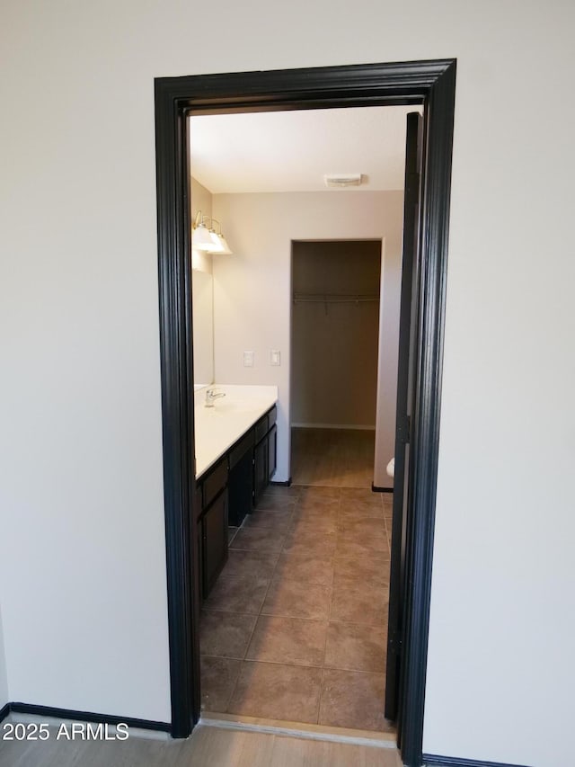 43241 W Kristal Ln, Maricopa, AZ 85138 - bathroom with vanity, a walk in closet, and tile patterned flooring
