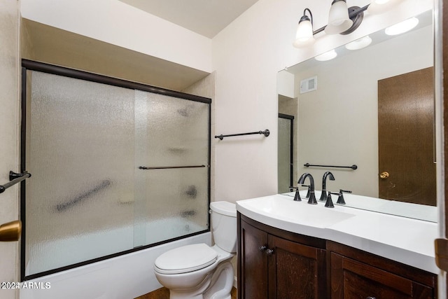 full bathroom featuring vanity, toilet, and shower / bath combination with glass door