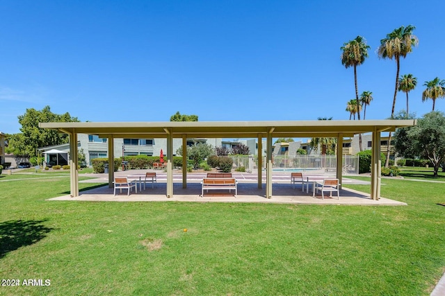 view of property's community featuring a patio area and a lawn