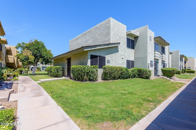 view of side of home with a balcony and a yard