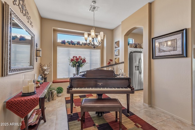 sitting room featuring arched walkways, visible vents, light tile patterned flooring, a chandelier, and baseboards