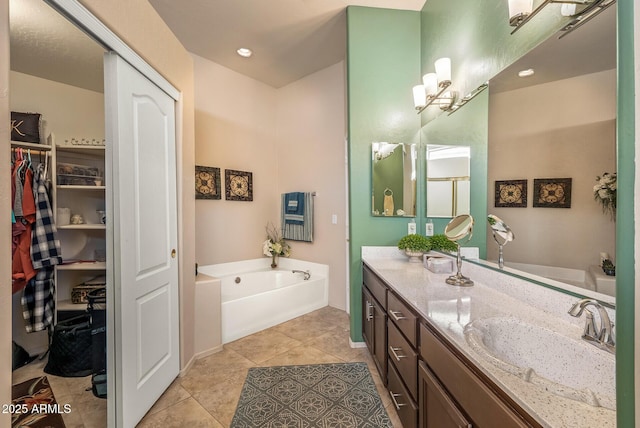 full bath with a garden tub, vanity, and tile patterned floors