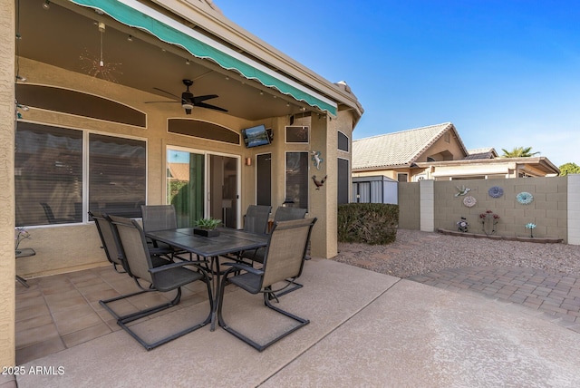 view of patio featuring a ceiling fan, outdoor dining area, and fence