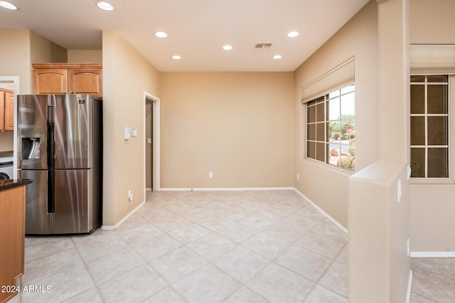 kitchen featuring stainless steel fridge and light tile patterned floors