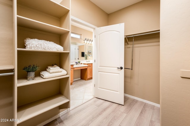 walk in closet with light hardwood / wood-style floors