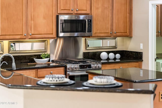 kitchen featuring appliances with stainless steel finishes and dark stone counters