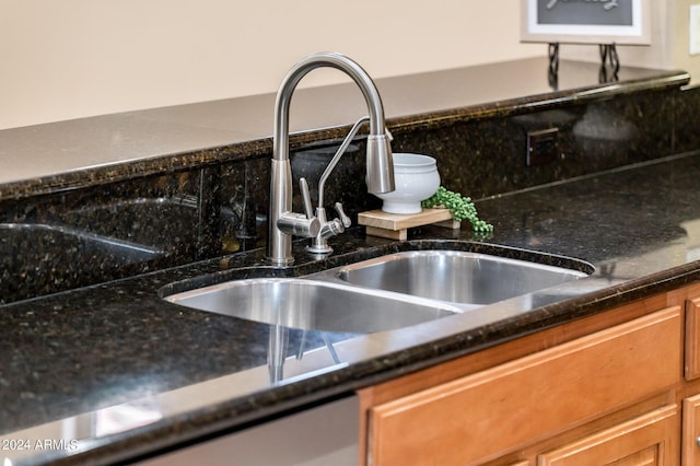 room details featuring dark stone countertops, sink, and tasteful backsplash