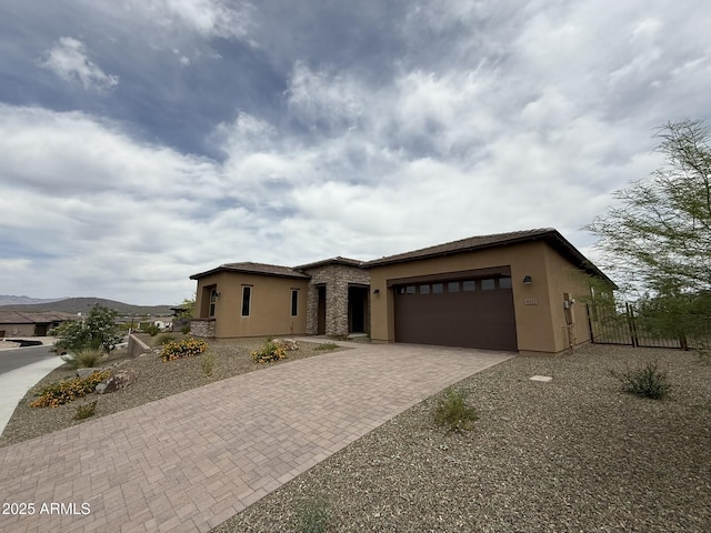 4017 Fence Post Way, Wickenburg, AZ 85390 - view of front of home featuring stucco siding, decorative driveway, a garage, and a tiled roof