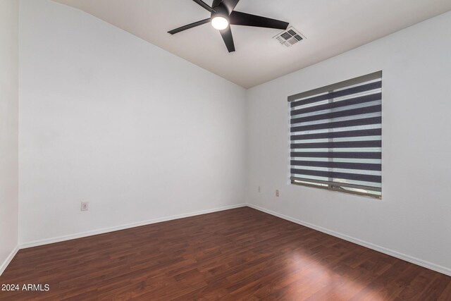empty room with baseboards, dark wood-style floors, visible vents, and ceiling fan