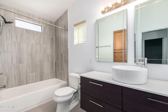 full bathroom featuring vanity, tiled shower / bath combo, toilet, and tile patterned flooring