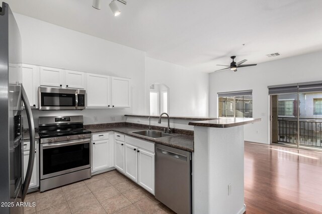 kitchen featuring a sink, visible vents, a ceiling fan, a peninsula, and appliances with stainless steel finishes