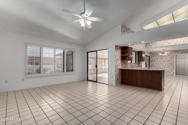 kitchen with kitchen peninsula, decorative backsplash, ceiling fan, lofted ceiling, and light tile patterned flooring