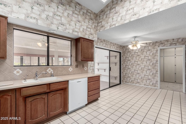 kitchen featuring ceiling fan, sink, white dishwasher, and light tile patterned flooring