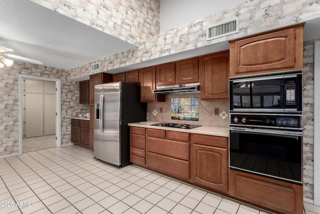 kitchen with ceiling fan, backsplash, a textured ceiling, light tile patterned flooring, and black appliances