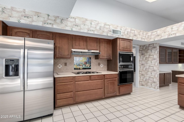 kitchen featuring black appliances, light tile patterned floors, and tasteful backsplash