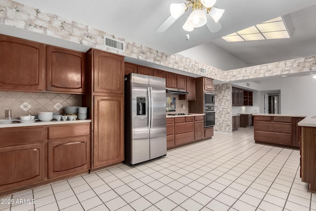 kitchen with ceiling fan, stainless steel appliances, tasteful backsplash, lofted ceiling, and light tile patterned floors