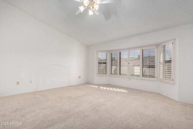 carpeted empty room featuring ceiling fan and lofted ceiling