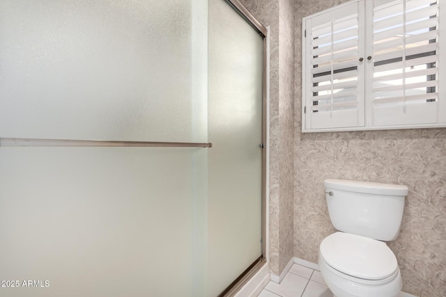 bathroom with tile patterned floors, a shower with door, and toilet