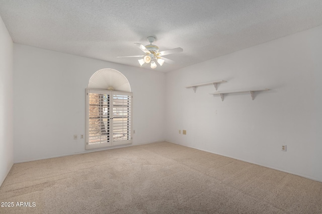 carpeted spare room with ceiling fan and a textured ceiling