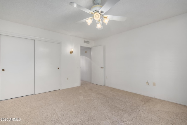 unfurnished bedroom with carpet flooring, ceiling fan, and a closet