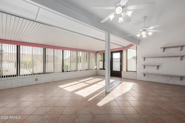 unfurnished sunroom with ceiling fan