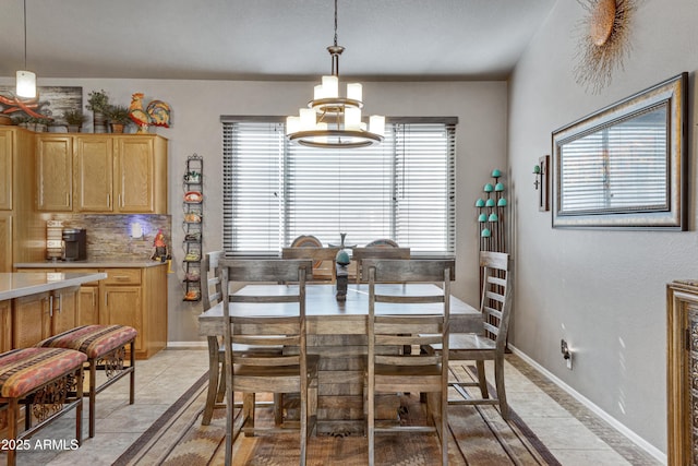 tiled dining space featuring a notable chandelier