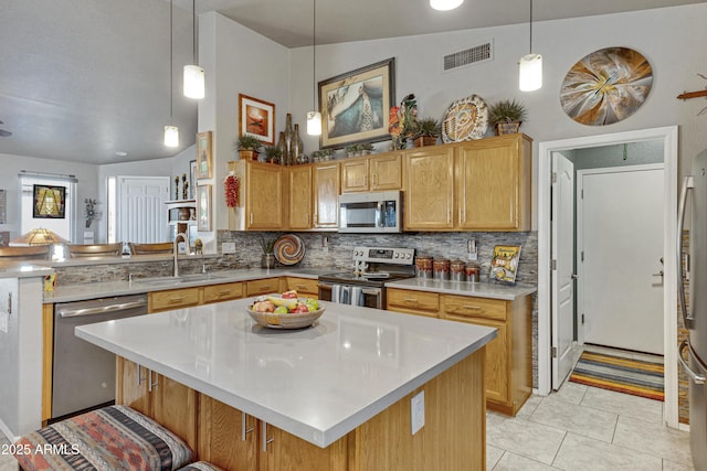 kitchen with decorative light fixtures, stainless steel appliances, vaulted ceiling, and sink