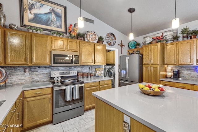 kitchen featuring appliances with stainless steel finishes, decorative light fixtures, and lofted ceiling