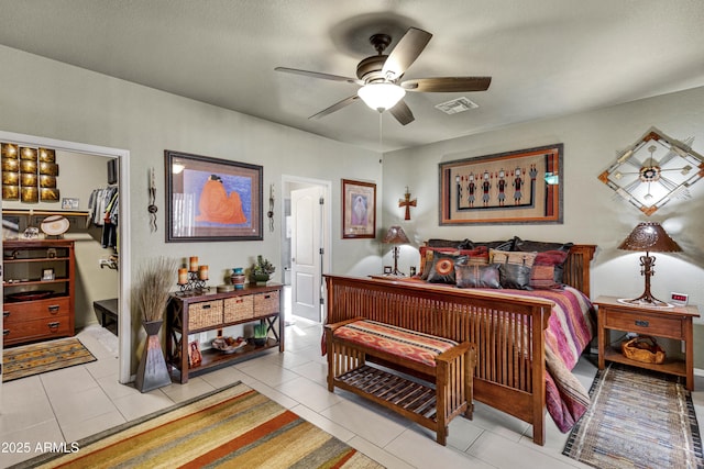 bedroom featuring a textured ceiling, ceiling fan, light tile patterned floors, a spacious closet, and a closet