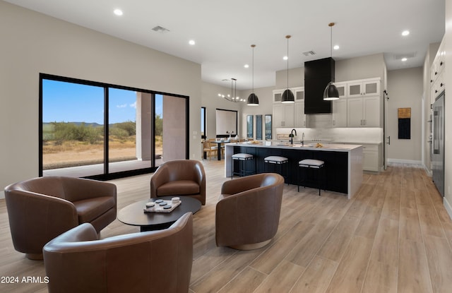 living room featuring a chandelier, light wood finished floors, visible vents, and recessed lighting