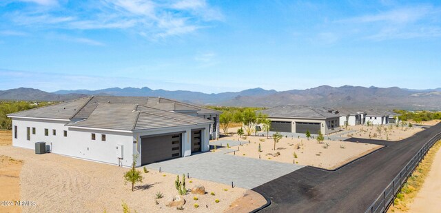 view of front of home featuring a mountain view, central AC, and a garage