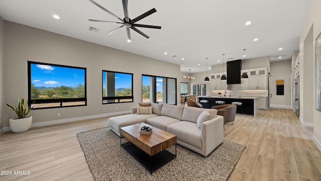 living room featuring light wood-type flooring, baseboards, visible vents, and recessed lighting