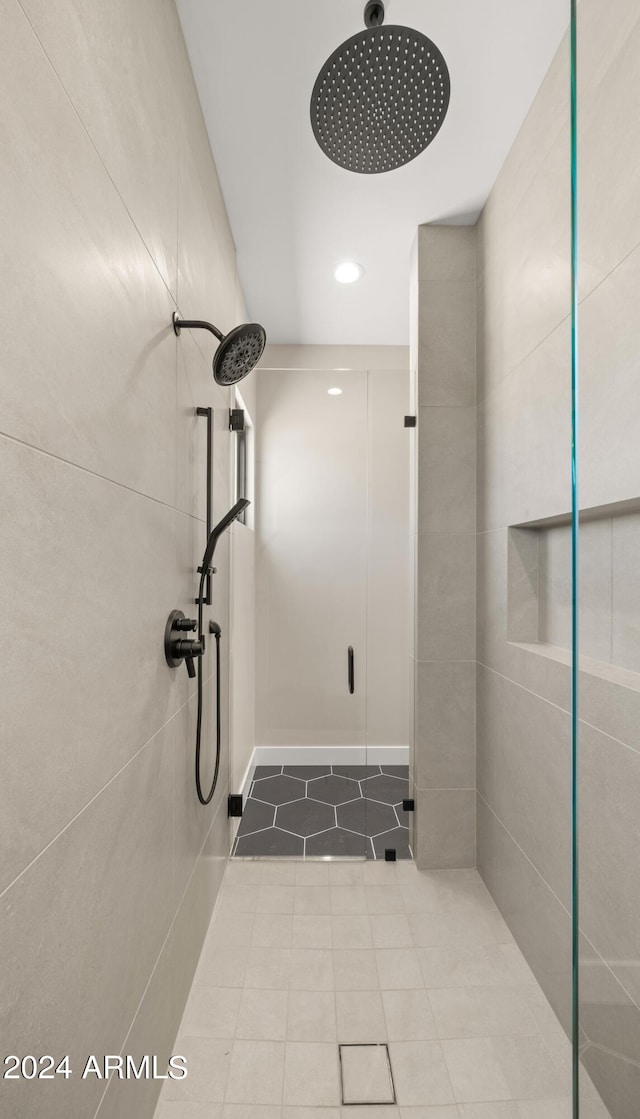 bathroom with a stall shower and tile patterned flooring