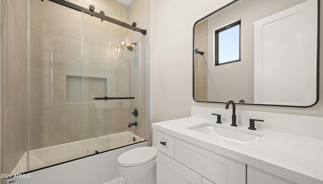 full bath featuring enclosed tub / shower combo, vanity, and toilet