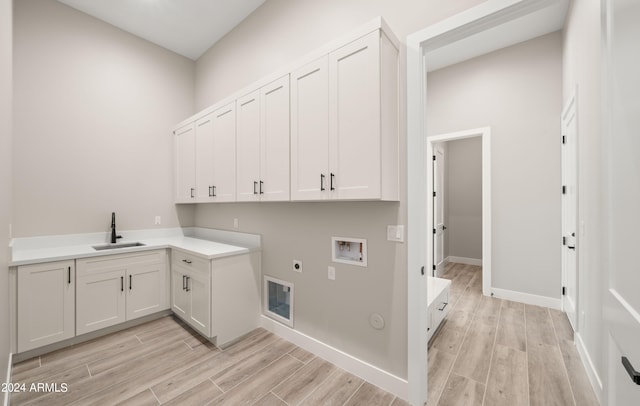 laundry room featuring cabinet space, wood tiled floor, washer hookup, and a sink