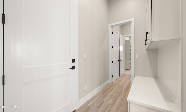 mudroom featuring wood finish floors and baseboards