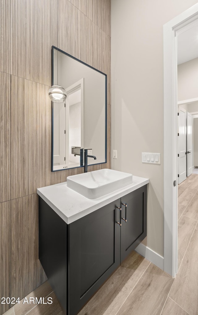 bathroom featuring wood finished floors, vanity, and baseboards