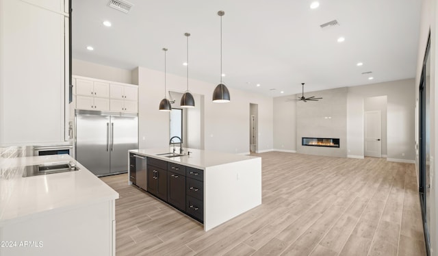 kitchen with light countertops, appliances with stainless steel finishes, visible vents, and pendant lighting