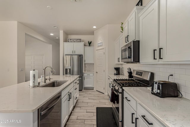 2716 S Chatsworth, Mesa, AZ 85209 - kitchen featuring appliances with stainless steel finishes, recessed lighting, white cabinetry, a kitchen island with sink, and tasteful backsplash