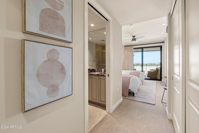 hall featuring light colored carpet and sink