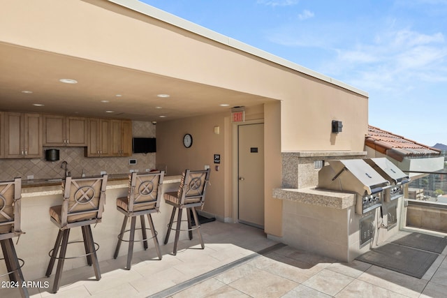 view of patio / terrace with an outdoor wet bar and an outdoor kitchen