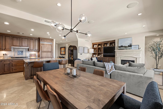 dining space with light tile flooring, a fireplace, and built in shelves