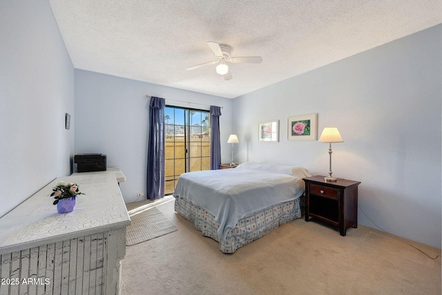 bedroom featuring light colored carpet, a textured ceiling, and ceiling fan