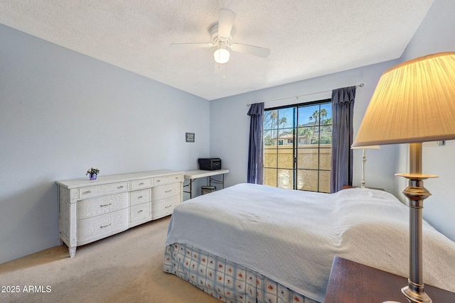 bedroom with a ceiling fan, light colored carpet, and a textured ceiling