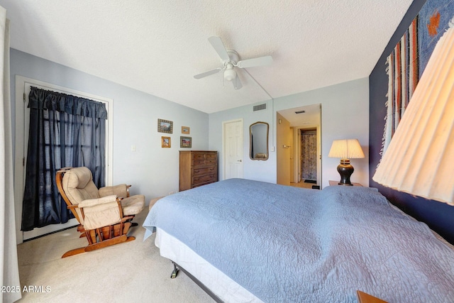 bedroom featuring a ceiling fan, carpet, visible vents, and a textured ceiling