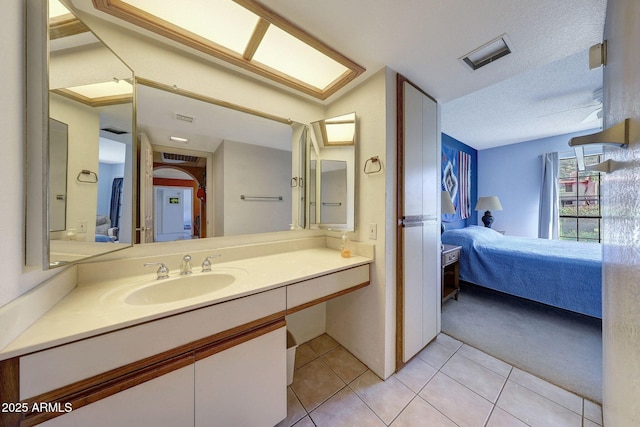 ensuite bathroom featuring tile patterned flooring, visible vents, vanity, and ensuite bathroom