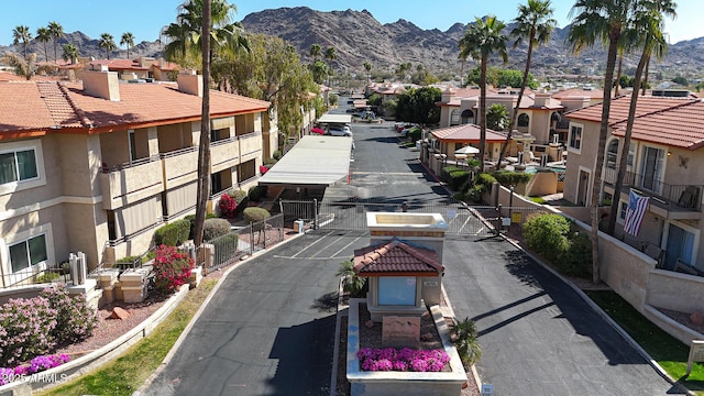 exterior space featuring curbs, a mountain view, a residential view, and a gated entry